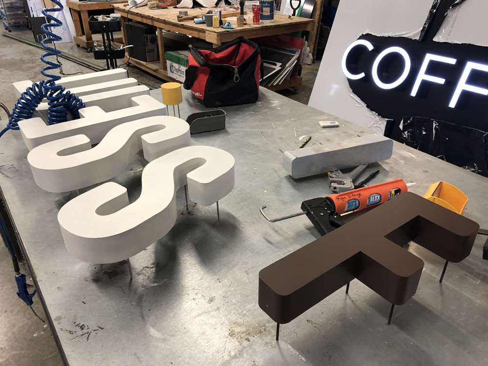 Dimensional sign letters arranged for assembly on the SignVillage worktable