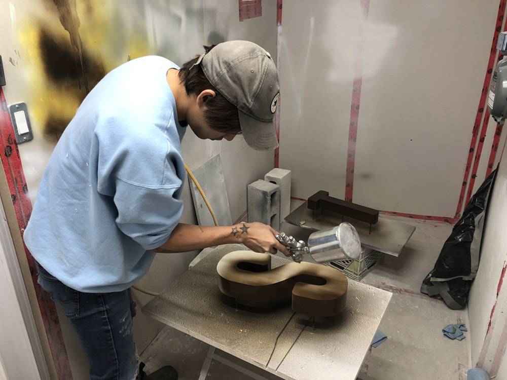 Sign letters receiving a sprayed finish inside the fabrication shop